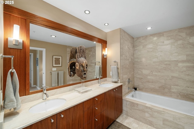 full bath with a tub, double vanity, and recessed lighting