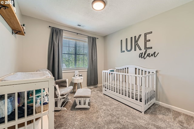 607 E Kennedy Ct, Carlton, OR 97111 - bedroom featuring carpet floors, baseboards, a textured ceiling, and a nursery area