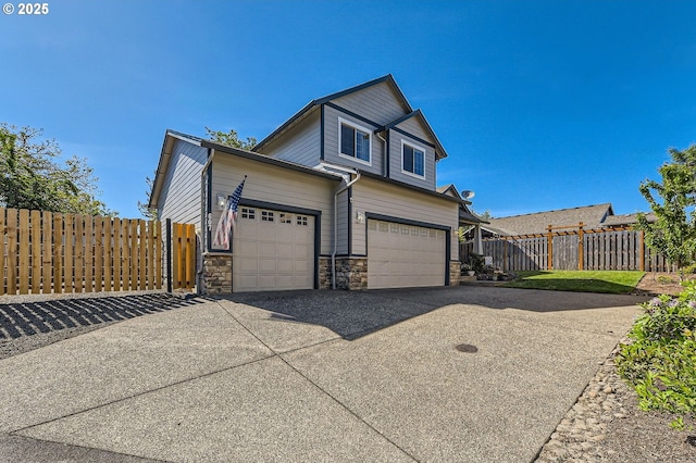 607 E Kennedy Ct, Carlton, OR 97111 - view of side of property with driveway, stone siding, and an attached garage