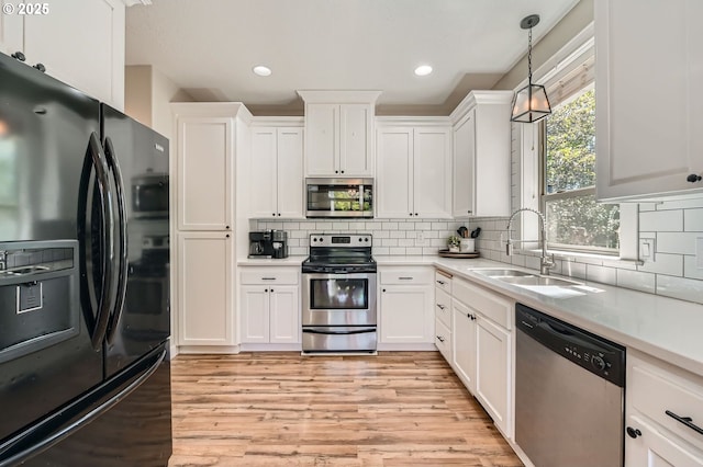 607 E Kennedy Ct, Carlton, OR 97111 - kitchen featuring appliances with stainless steel finishes, a sink, light wood finished floors, white cabinets, and recessed lighting
