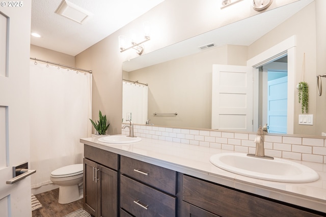 840 Chikamin Loop, Silverton, OR 97381 - bathroom featuring double vanity, toilet, wood finished floors, and curtained shower