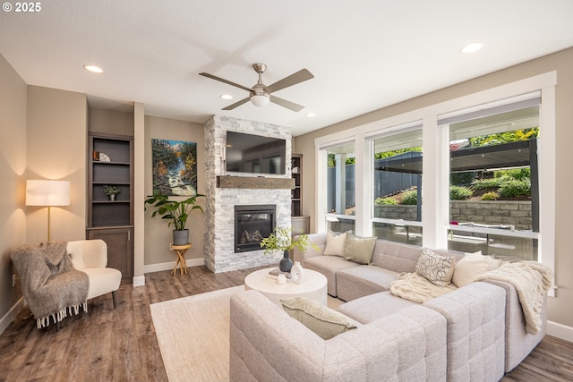 840 Chikamin Loop, Silverton, OR 97381 - living room featuring wood finished floors, baseboards, ceiling fan, a stone fireplace, and recessed lighting