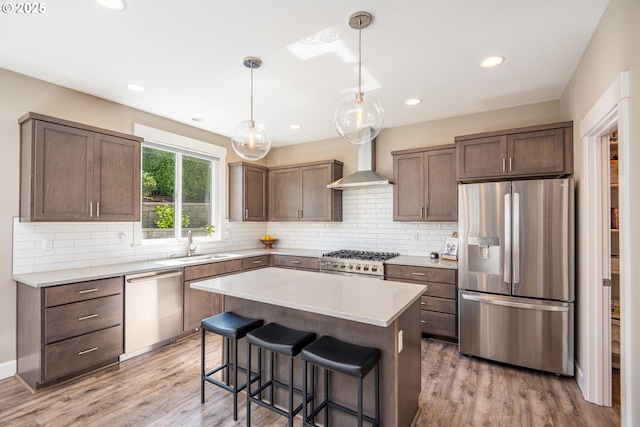 840 Chikamin Loop, Silverton, OR 97381 - kitchen with stainless steel appliances, wall chimney exhaust hood, a sink, light wood-type flooring, and recessed lighting