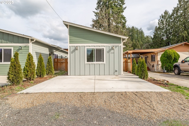 view of outdoor structure featuring concrete driveway and fence