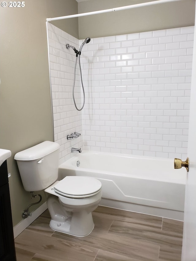 bathroom with toilet, vanity, wood finished floors, and shower / bathing tub combination