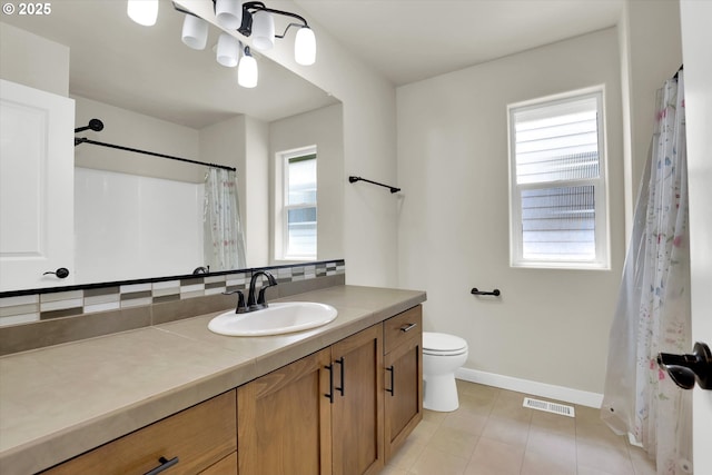 385 SW Mitchum Ter, Beaverton, OR 97006 - bathroom featuring healthy amount of natural light, vanity, tile patterned floors, and tasteful backsplash
