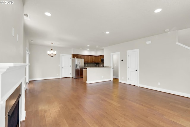 385 SW Mitchum Ter, Beaverton, OR 97006 - unfurnished living room featuring a chandelier, a fireplace, recessed lighting, and dark wood-style flooring