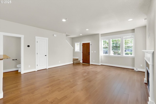 385 SW Mitchum Ter, Beaverton, OR 97006 - unfurnished living room with stairway, light wood finished floors, recessed lighting, and a fireplace