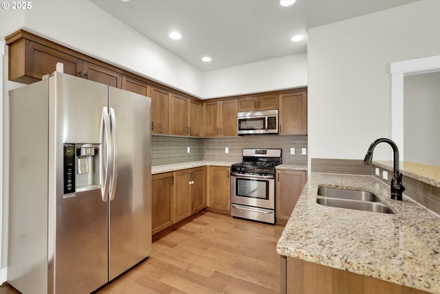 385 SW Mitchum Ter, Beaverton, OR 97006 - kitchen with appliances with stainless steel finishes, a peninsula, light stone countertops, tasteful backsplash, and brown cabinets