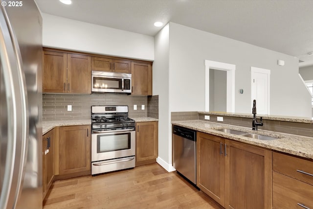 385 SW Mitchum Ter, Beaverton, OR 97006 - kitchen with appliances with stainless steel finishes, light wood-style flooring, brown cabinetry, and recessed lighting