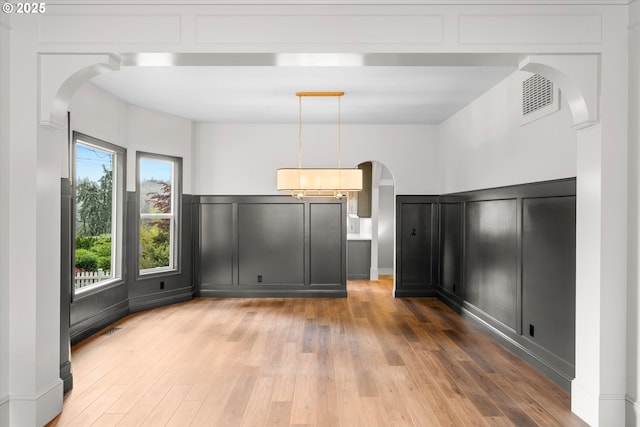 2089 5th Ave, West Linn, OR 97068 - unfurnished bedroom featuring arched walkways, a decorative wall, and light wood-style flooring