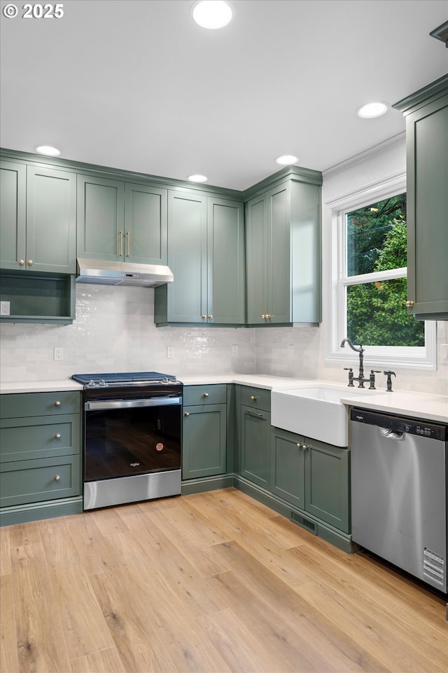2089 5th Ave, West Linn, OR 97068 - kitchen featuring stainless steel appliances, green cabinets, under cabinet range hood, and recessed lighting
