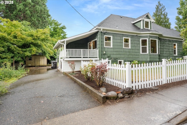 2089 5th Ave, West Linn, OR 97068 - view of front of home with driveway, a storage shed, a fenced front yard, and roof with shingles