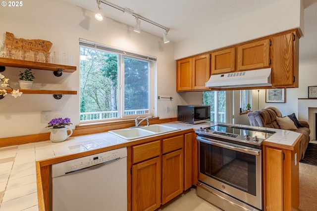 4216 SW Brugger St, Portland, OR 97219 - kitchen with white dishwasher, black microwave, a sink, under cabinet range hood, and stainless steel electric stove