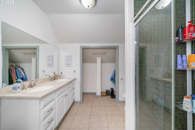 bathroom with double vanity, a sink, lofted ceiling, and tile patterned flooring