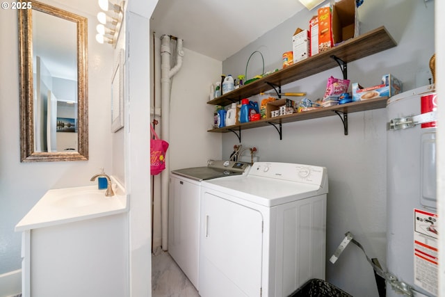 laundry area with laundry area, marble finish floor, washing machine and dryer, a sink, and water heater