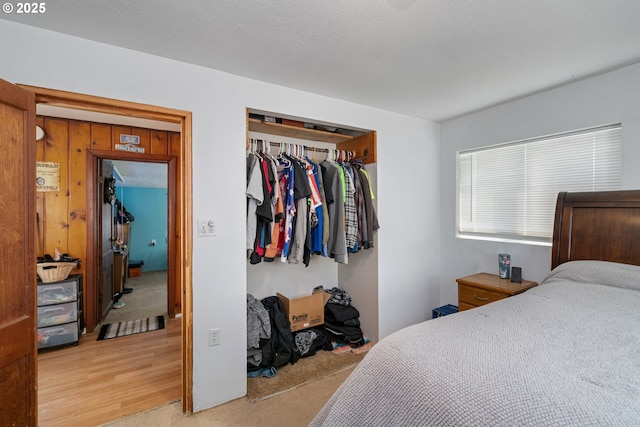 bedroom with light carpet, a closet, and light wood-type flooring