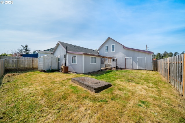 back of property featuring a yard, an outbuilding, a shed, and a fenced backyard