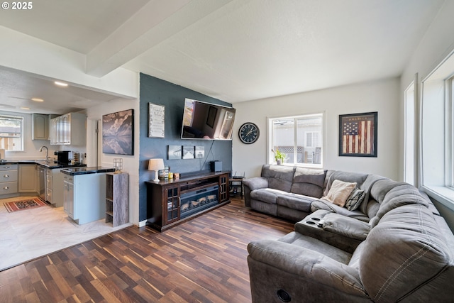 living area with beamed ceiling and wood finished floors