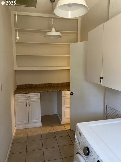 washroom with dark tile patterned flooring and washer / dryer