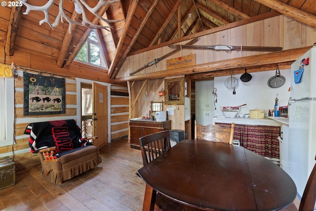 dining area featuring wooden walls, hardwood / wood-style floors, wood ceiling, high vaulted ceiling, and beamed ceiling