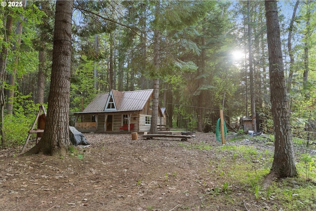 view of yard featuring a wooded view and covered porch