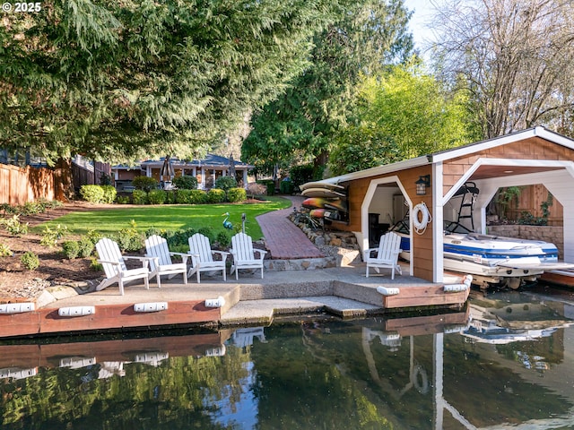 view of dock with a lawn and fence