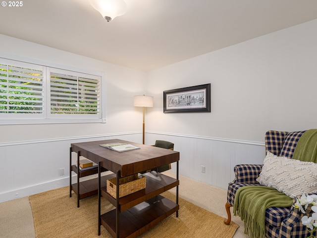 home office with a wainscoted wall and light carpet