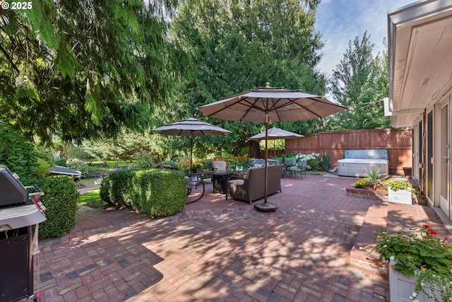 view of patio with outdoor dining space, a fenced backyard, and a hot tub