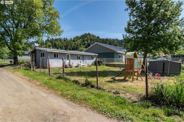 view of front of property with a playground and fence