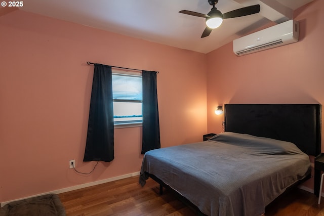 bedroom featuring wood finished floors, baseboards, ceiling fan, and a wall unit AC