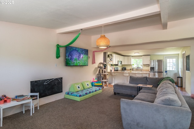 carpeted living area featuring beamed ceiling
