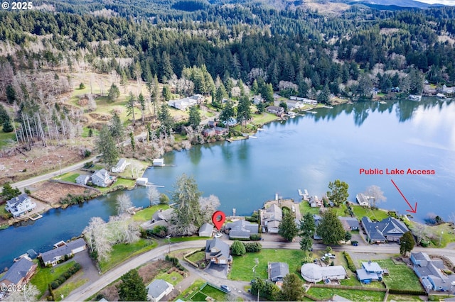 aerial view with a water view and a wooded view