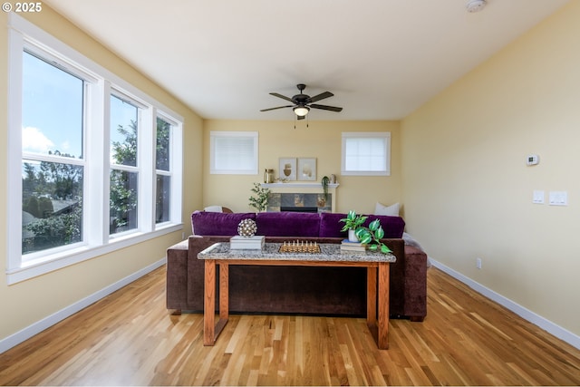 office space with light wood finished floors, a fireplace, and baseboards