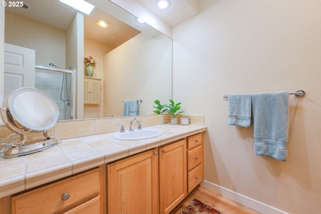 6641 NE Rosebay Dr, Hillsboro, OR 97124 - bathroom featuring a stall shower, vanity, wood finished floors, and baseboards