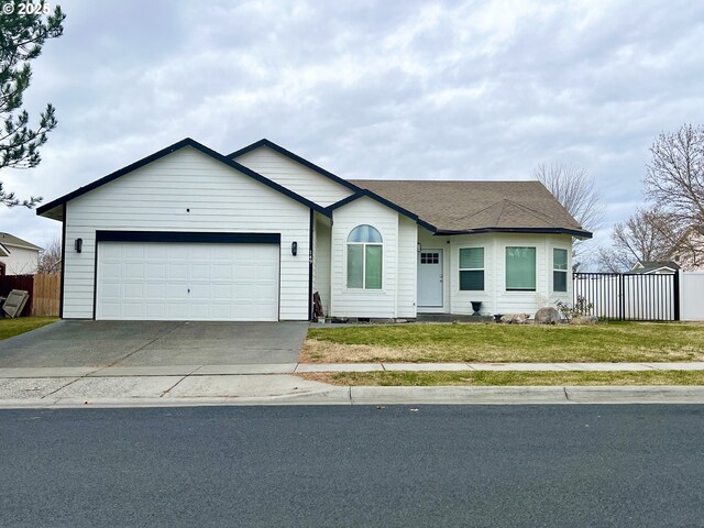 ranch-style house featuring a garage and a front lawn