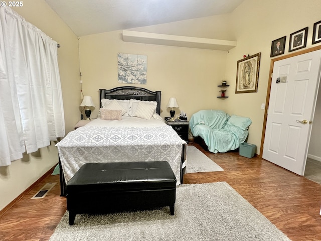 bedroom featuring hardwood / wood-style floors and vaulted ceiling