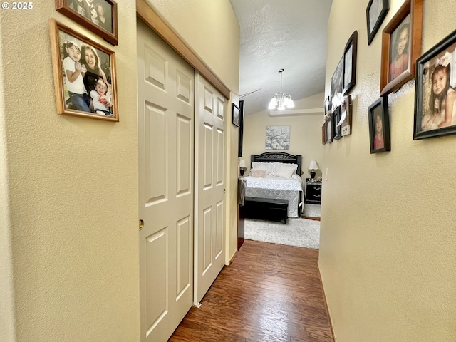 corridor featuring an inviting chandelier and dark hardwood / wood-style floors