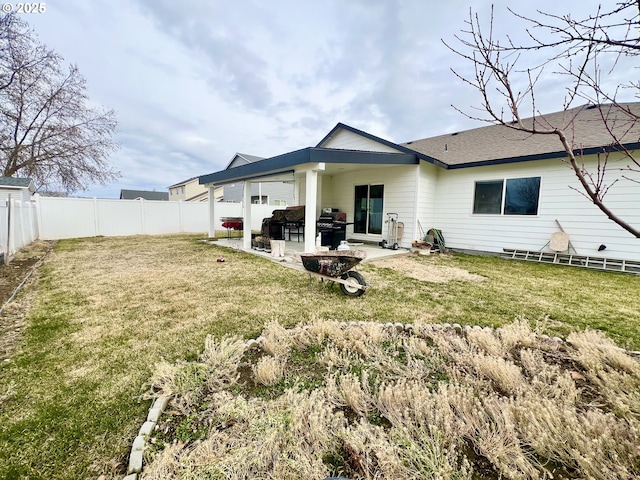 back of house with a patio and a lawn