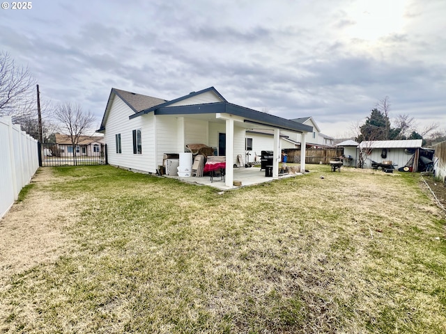 rear view of property featuring a yard and a patio