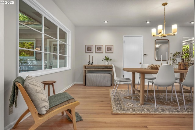 dining space with an inviting chandelier, recessed lighting, baseboards, and wood finished floors