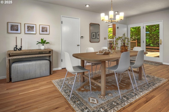 dining room with baseboards, wood finished floors, and a chandelier