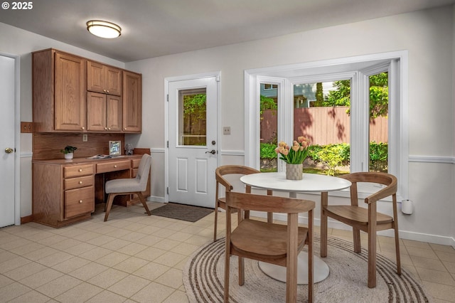 dining room with light tile patterned flooring, baseboards, and built in study area