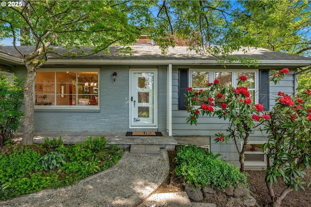 entrance to property featuring brick siding