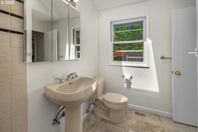 bathroom with toilet, baseboards, and visible vents
