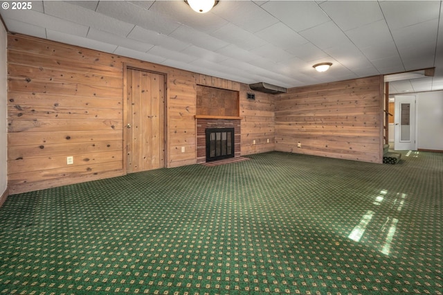 unfurnished living room featuring a glass covered fireplace and wood walls
