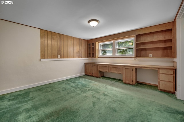 unfurnished office featuring baseboards, light colored carpet, and built in study area