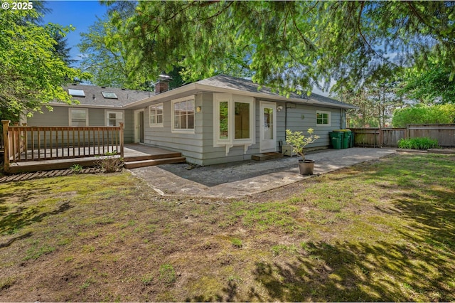 back of property with fence, a patio, a yard, and a deck