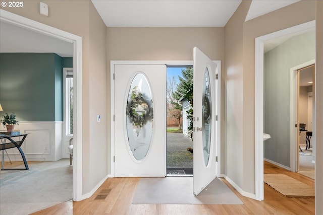 foyer with a healthy amount of sunlight, light wood-style flooring, and baseboards