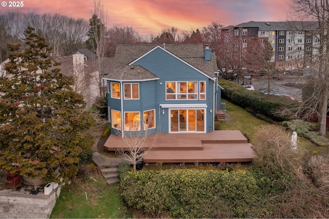 rear view of property with a wooden deck and a chimney